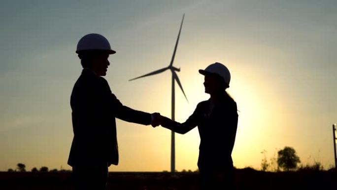 商业男女握手商业交易，涡轮机风力清洁无能力。