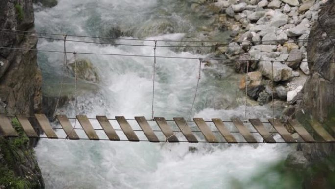在一条沸腾的山河上的吊桥。危险概念