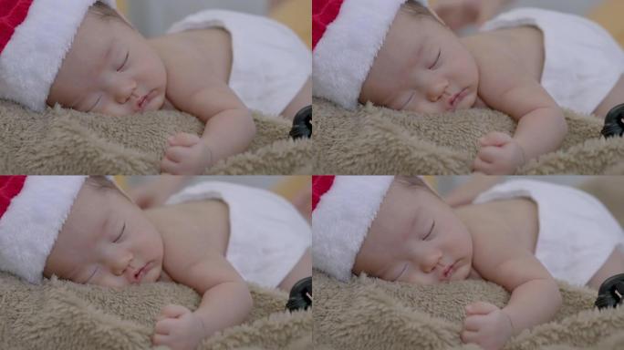 4k，一个亚洲新生婴儿戴着圣诞老人帽子睡在棕色地毯上的特写镜头。