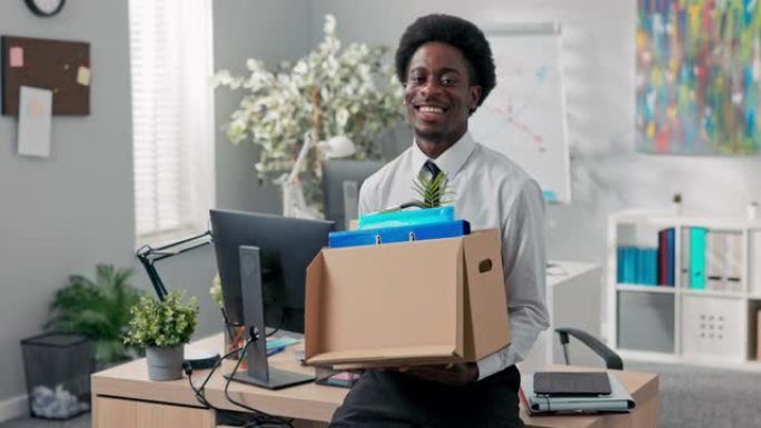 非洲裔男子辞职公司工作带着盒子里的东西走出办公室离开公司公司辞职责任退休离开社交室