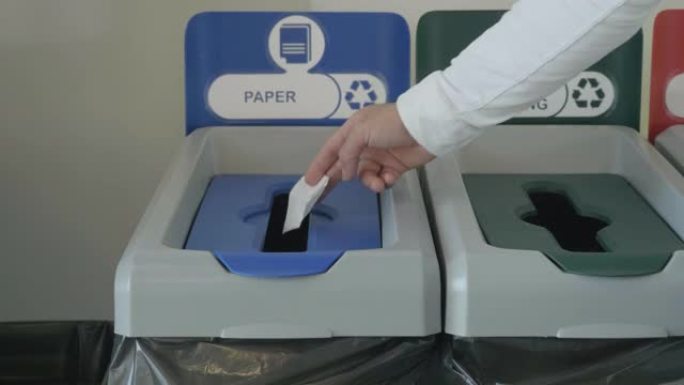 将一张纸扔在专门的垃圾箱中，用于废物回收，生态概念。HDR。将一小张纸放在回收箱中。
