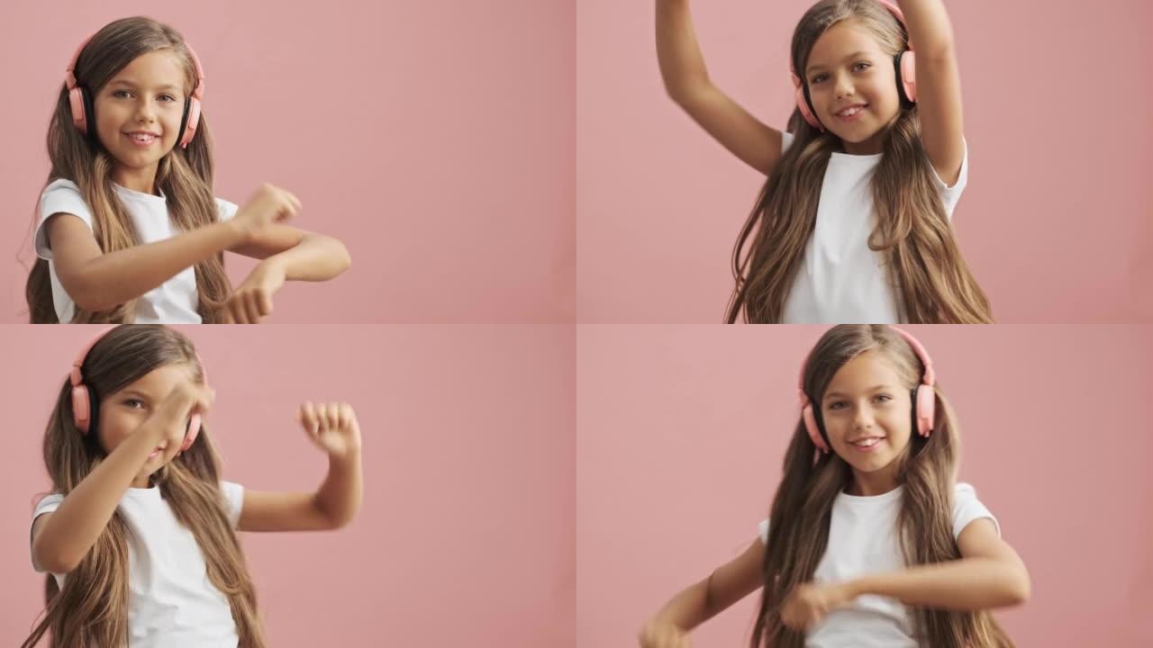 快乐的小女孩戴着粉色耳机听音乐跳舞