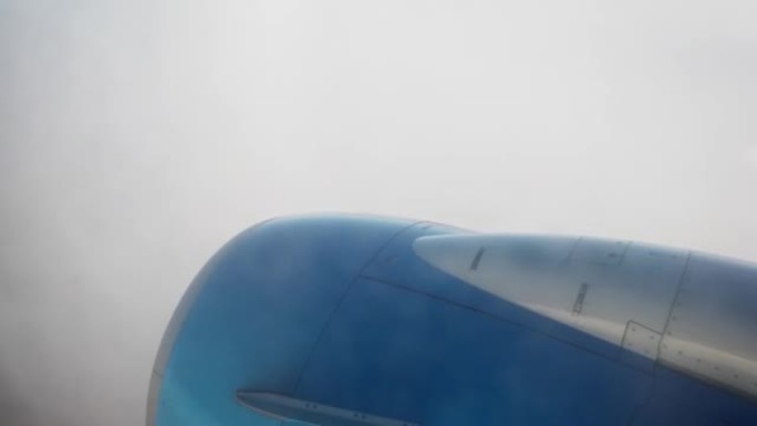 从窗户上的一架客机的窗户上看，你可以看到地面被发动机部分覆盖，迎面而来的浓雾