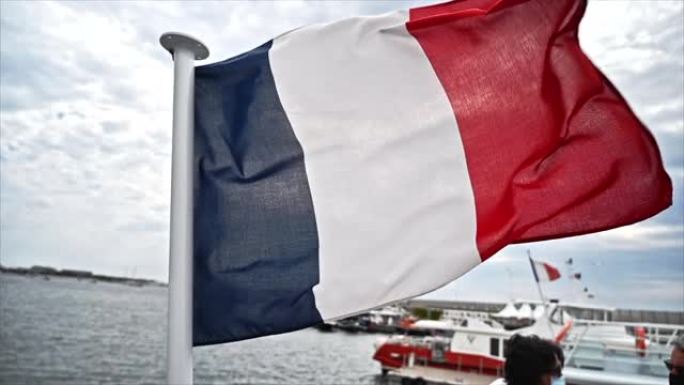 法国戛纳海港迎风飘扬的法国国旗。慢动作
