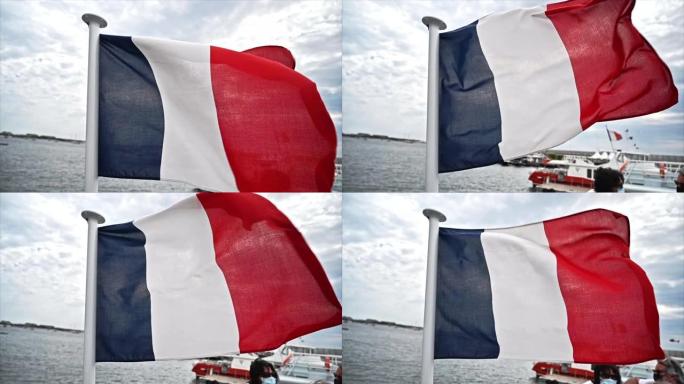 法国戛纳海港迎风飘扬的法国国旗。慢动作