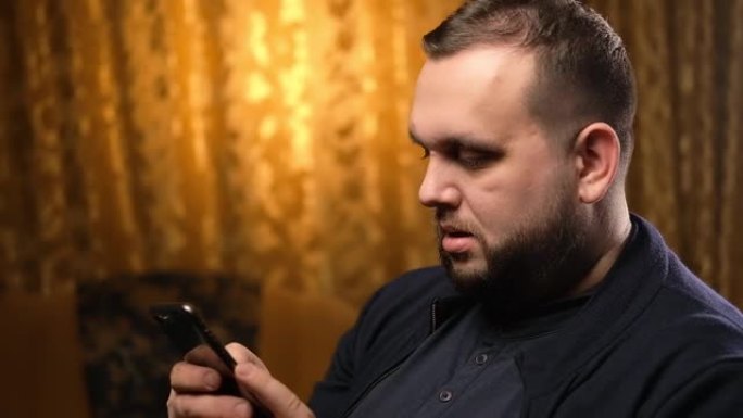 乌克兰基辅-2022年1月15日: 一个留着胡须的年轻人，手里拿着苹果手机。