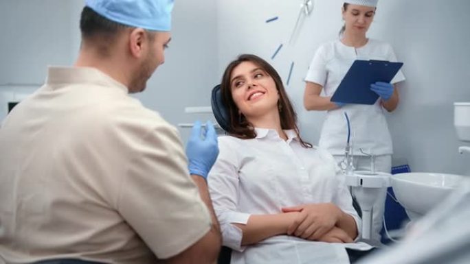 微笑的女病人在定期体检诊所咨询男牙医