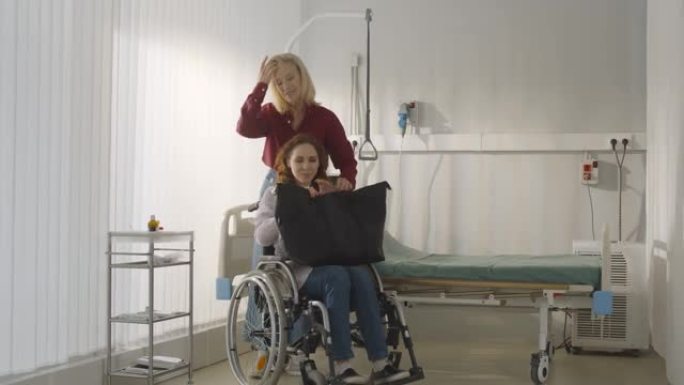老年妇女推着轮椅与女儿出院