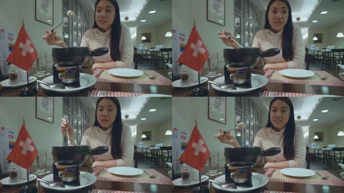 在瑞士吃奶酪火锅的快乐年轻女子。