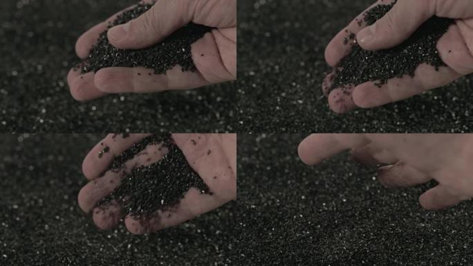 裸露的高加索人手持慢动作倒入少量黑色活性炭椰子炭粉