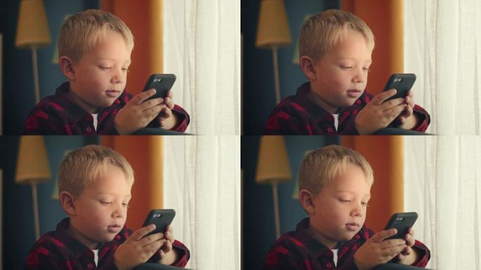 小男孩用智能手机玩游戏在家放松孩子用手机技术在线浏览防社交成瘾概念