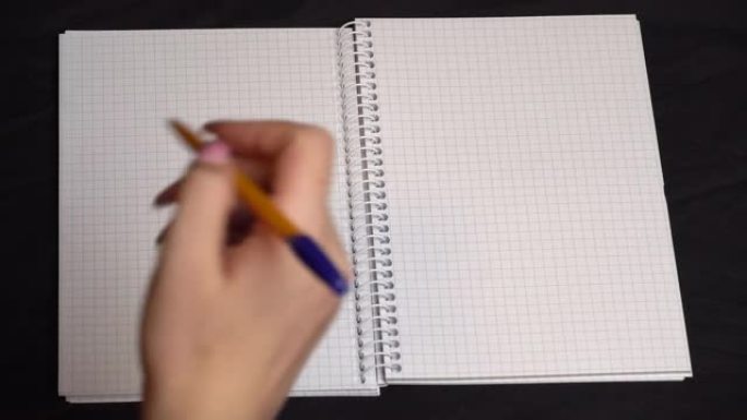 女孩用笔在笔记本上画一颗心