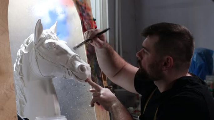 工匠根据石膏模型创造马。石膏模具和塑料面具雕刻和绘画