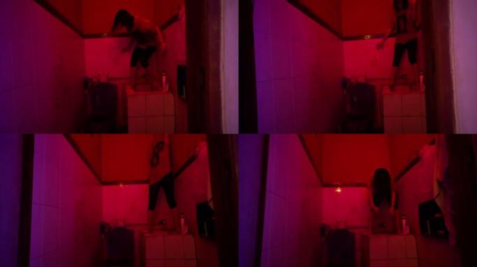 亚洲妇女在红色房间的灯光下洗澡时生气地跳舞