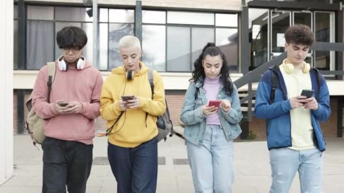 一群多种族的青少年学生在放学后使用手机