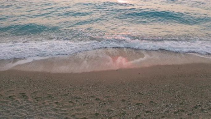 希腊爱奥尼亚岛莱夫卡达美丽的米洛斯海滩的低海拔空中视图。日落金色的阳光和原始的海浪打破了岸上碧蓝的大