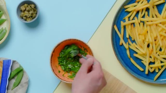 垂直平放视频: 厨师将酱汁和香草混合成炸薯条