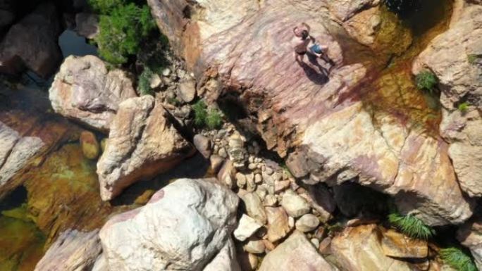 夫妇在南非阳光明媚的岩石上晒日光浴
