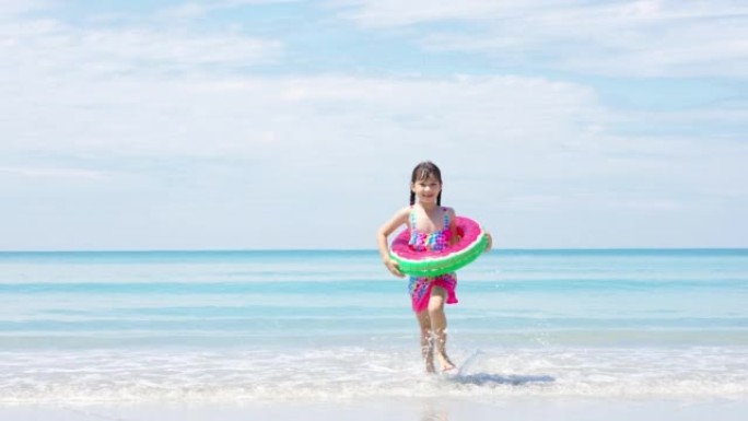 4k亚洲小女孩在夏日晴天在热带海滩上奔跑和玩耍的肖像。