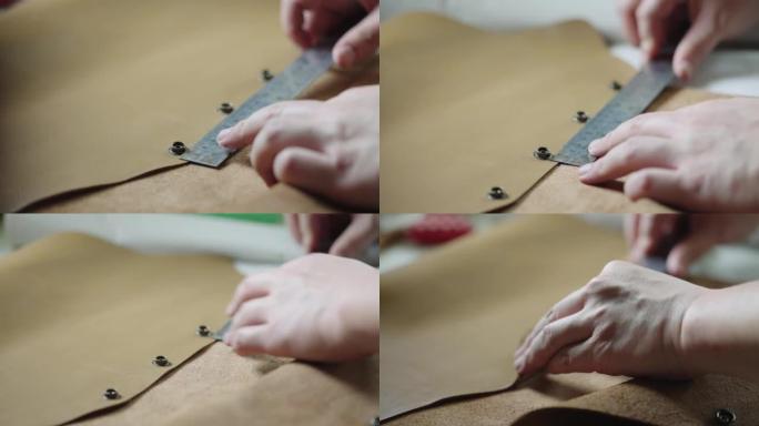 坦纳的手用尺子测量皮革产品上的金属纽扣。
