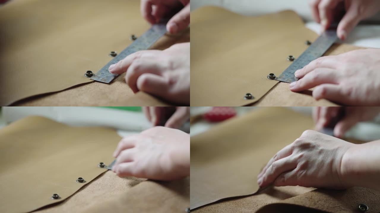 坦纳的手用尺子测量皮革产品上的金属纽扣。