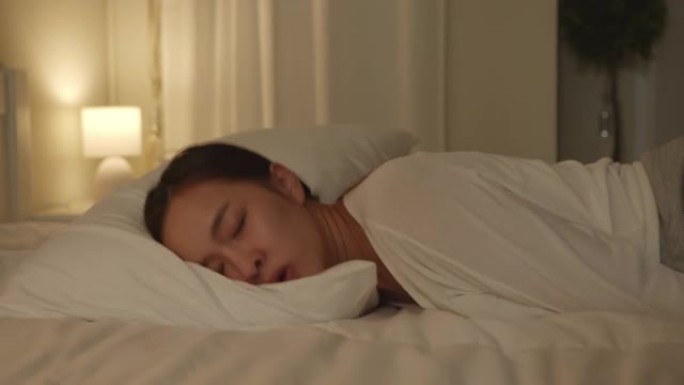 久经考验，疲惫不堪的年轻亚洲妇女晚上躺在床上