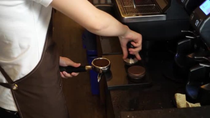 双手支撑并用力将浓缩咖啡篡改压入Portafilter
