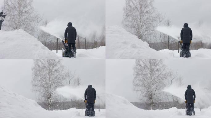 男子在院子里用机械扫雪机除雪。后视图。慢动作