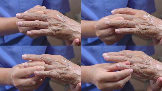 护理人员按摩痛风肿胀的老年妇女的手指。