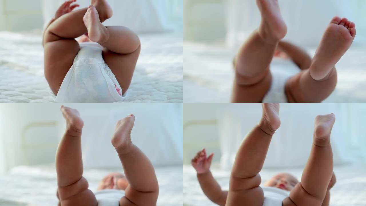可爱的黑宝宝躺在柔软的床上玩脚，高兴地举起手和腿。