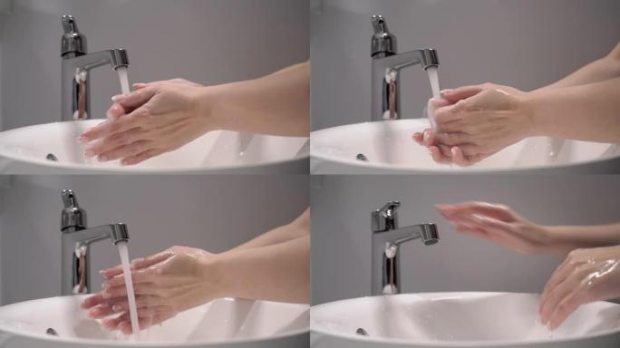 女人洗手。女性用水打开水龙头，双手在水槽中冲洗
