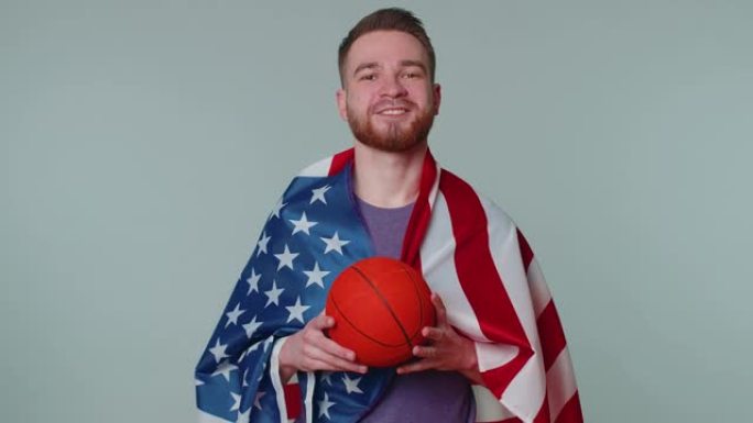 留着大胡子的年轻篮球迷举着美国国旗做获胜者的手势，独自跳舞