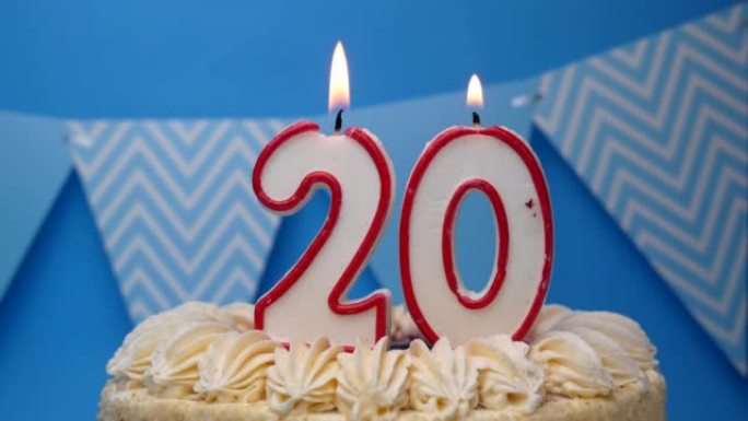 生日快乐。20年，纸杯蛋糕，蓝色背景上的蜡烛生日蛋糕。特写