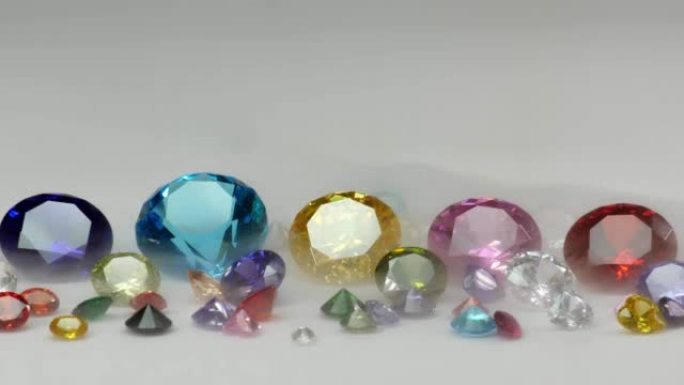 各种尺寸的彩色钻石在白色背景上闪闪发光。