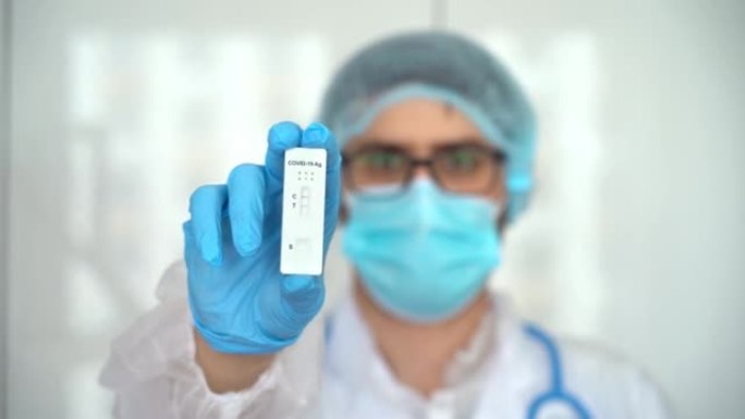 男性医生在防护面罩持有PCR测试冠状病毒。快速拭子法新型冠状病毒肺炎，快速抗原检测