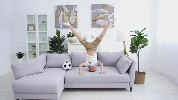 自信快乐迷人的运动型12岁男孩穿着家装的特写镜头，在家沙发上做架子
