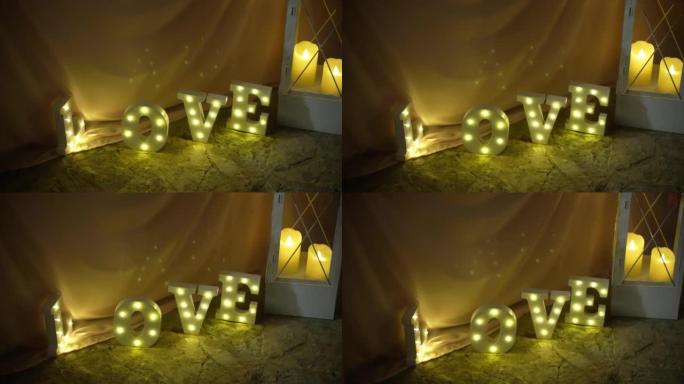 浪漫的灯光装饰在地面上，字母的意思是单词爱照亮房间附近有燃烧的蜡烛。假日派对上的霓虹灯，活动庆祝用明
