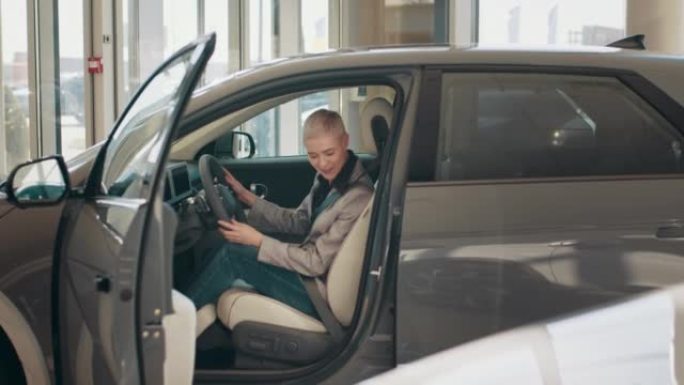 生态汽车销售概念。具有自动驾驶系统的新一代电动汽车的试驾。迷人的白人妇女坐在新现代汽车的方向盘后面。