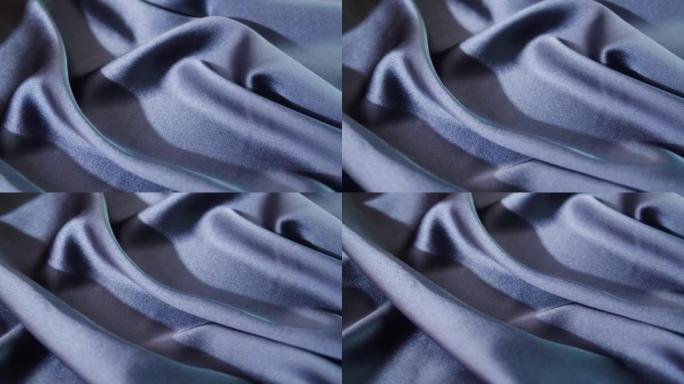 真丝蓝色面料特写。缝纫服装的布料质地。纺织品的宏观拍摄。针线活和定制。