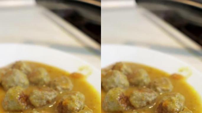 冷冻肉半成品，煎锅里有酱汁的蔬菜肉丸，垂直视频。