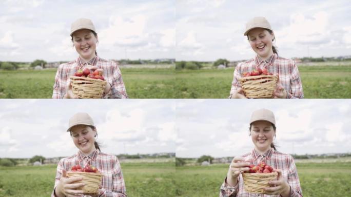 戴帽子的女人拿着草莓篮子。农民喜欢水果的香气。