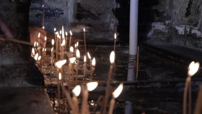 前往教堂朝圣的妇女点燃蜡烛，以纪念靠近他们的亲人