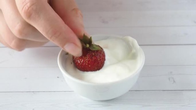 草莓蘸有新鲜奶油，一种美味的夏季甜点。特写。