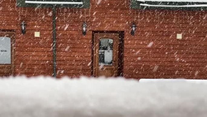 雪落在房子后院外面的地面上。转移对雪花的关注