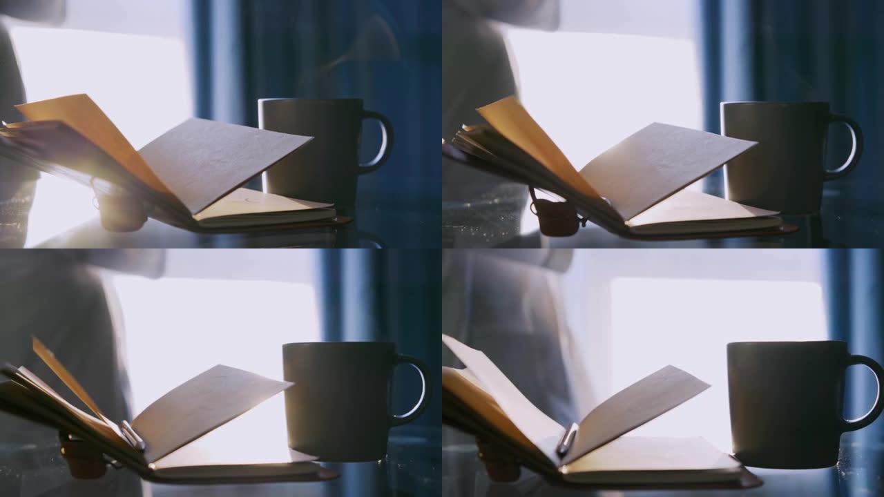 玻璃桌上的咖啡杯和纸日记