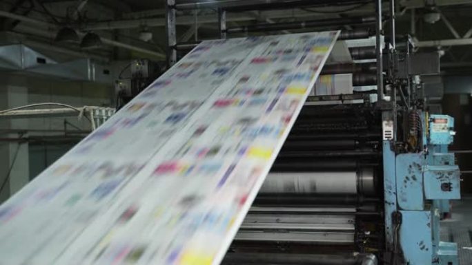 大型机器、传送带上彩印报纸。一卷卷的纸在印刷机上画出来。印刷的房子。媒体，文章，标题，每日新闻，印刷