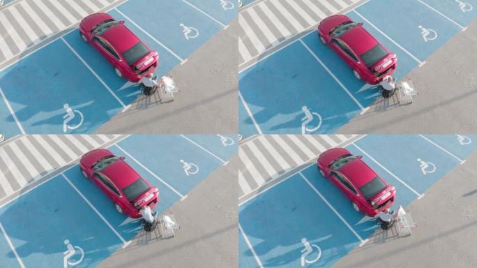 患有身体残疾的成年人使用轮椅司机从轮椅上乘坐红色汽车