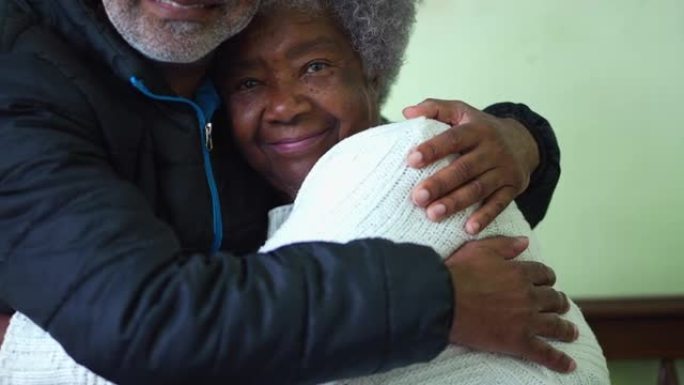 一个黑人成年儿子抱着资深母亲一起摆姿势拍照