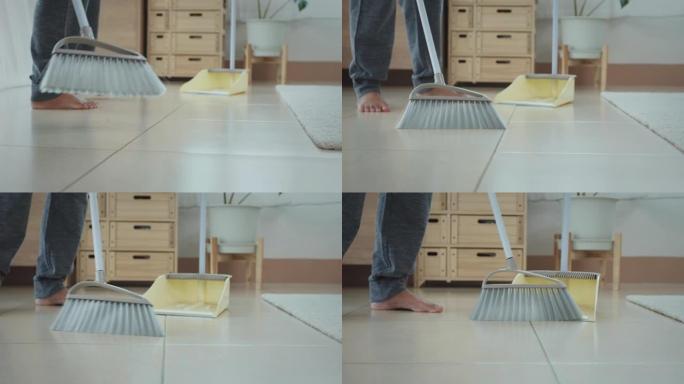 女人用扫帚清洁和扫除地板上的灰尘