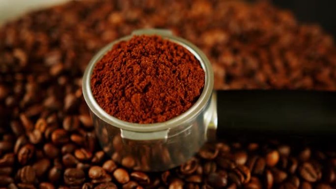 在带有咖啡豆的木板上的portafilter磨碎的咖啡。过滤器支架中的现磨咖啡和烤豆，用于制备芳香饮